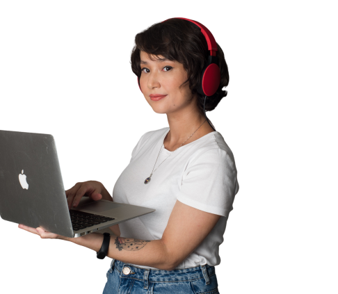 imagem de uma mulher usando headphone, utilizando um macbook