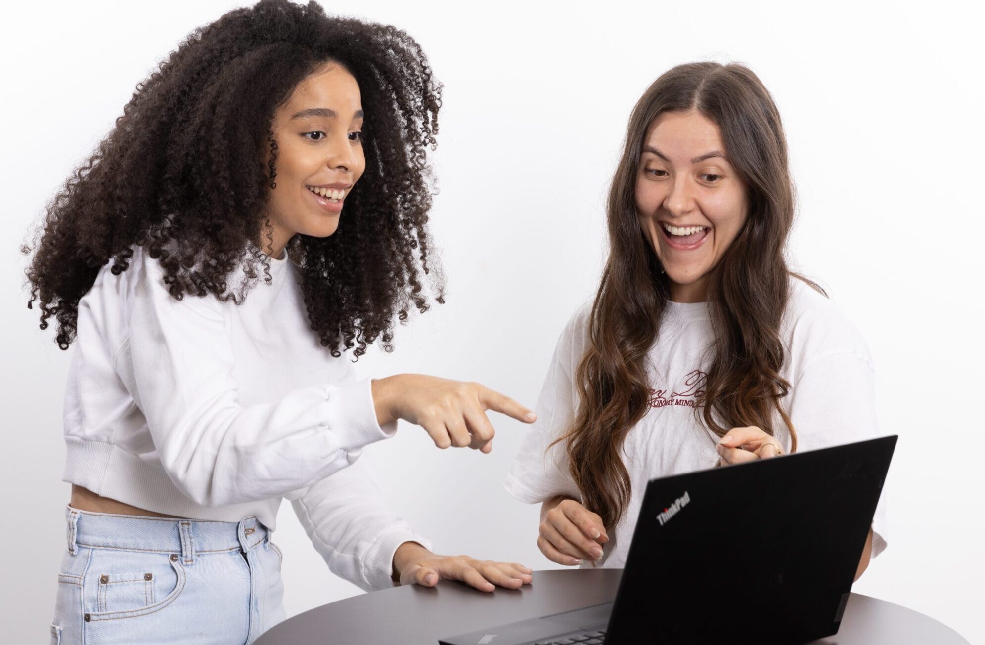 Duas mulheres conversando e usando um computador
